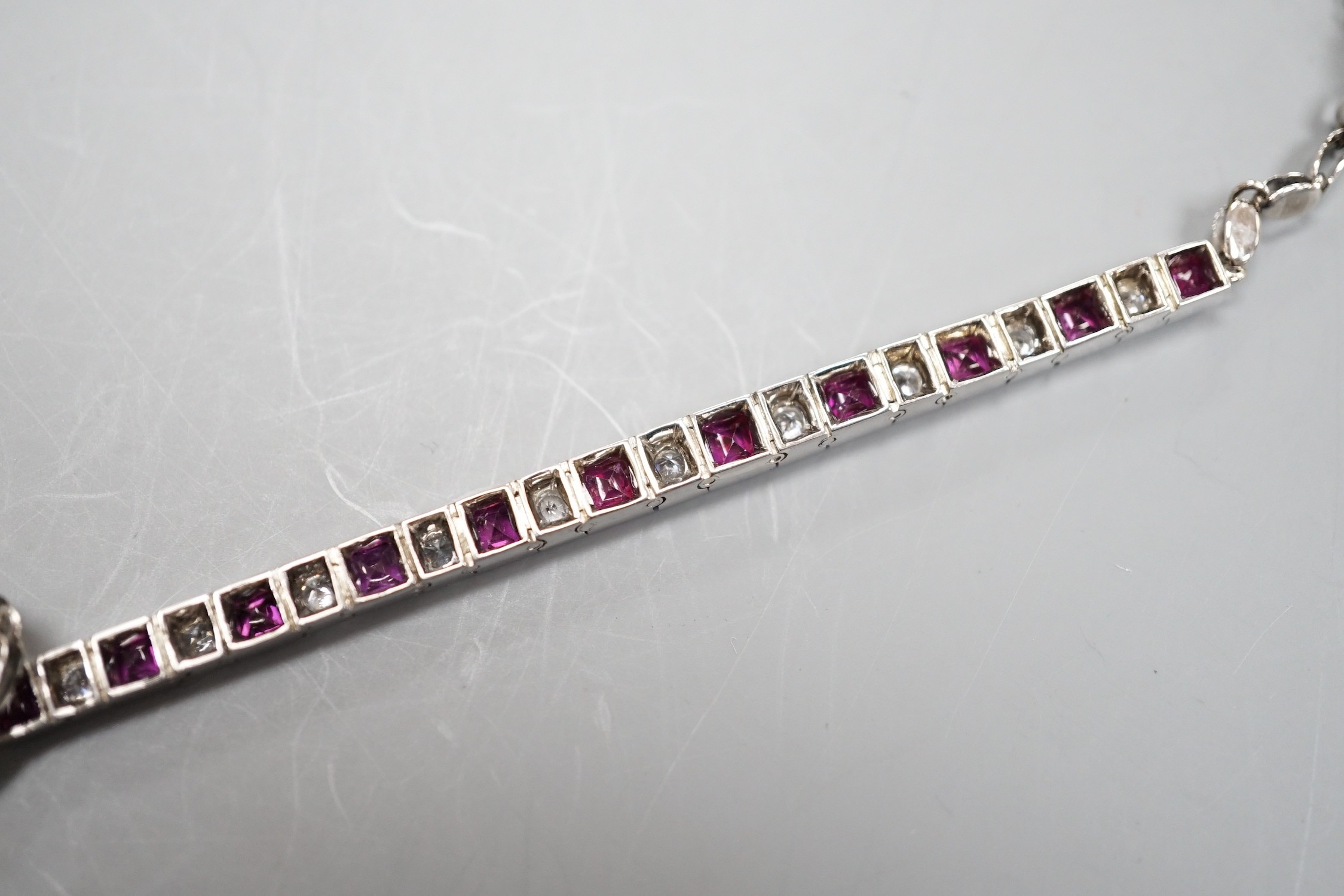 A white metal, ruby and white spinel set line bracelet, 16cm, gross weight 8.4 grams.